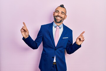 Young hispanic man wearing business suit and tie smiling confident pointing with fingers to different directions. copy space for advertisement