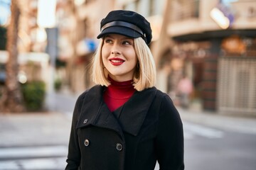 Young blonde woman smiling happy standing at the city.