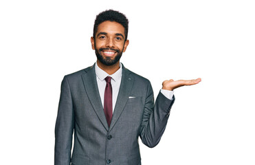 Young african american man wearing business clothes smiling cheerful presenting and pointing with palm of hand looking at the camera.