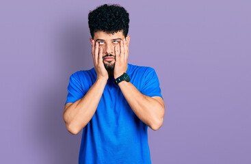 Young arab man with beard wearing casual blue t shirt tired hands covering face, depression and sadness, upset and irritated for problem