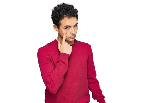 Young handsome man wearing casual clothes pointing to the eye watching you gesture, suspicious expression