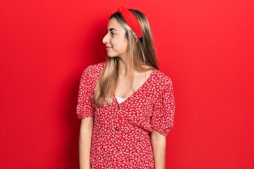 Beautiful hispanic woman wearing summer dress looking to side, relax profile pose with natural face with confident smile.