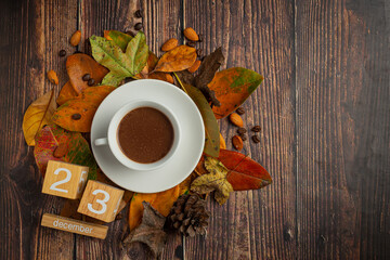 Obraz na płótnie Canvas A cup of coffee lying on the floor and a calendar with dry leaves.