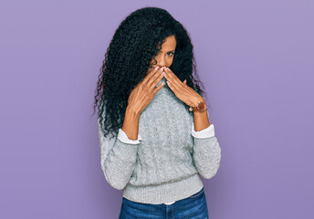Middle age african american woman wearing casual clothes laughing and embarrassed giggle covering...