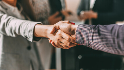 close up. young casual business people shaking hands with each - obrazy, fototapety, plakaty