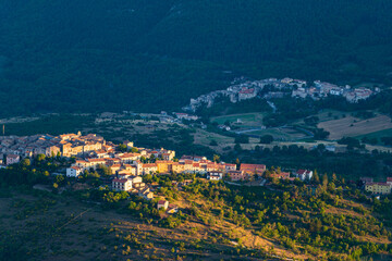 Obraz premium Sunset over medieval village perched on hill top, Abruzzo, Italy. Gran Sasso National Park, mountains landscape, tourism destination.
