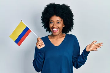 Foto op Canvas Young african american woman holding colombia flag celebrating achievement with happy smile and winner expression with raised hand © Krakenimages.com