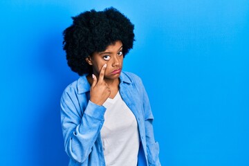Fototapeta na wymiar Young african american woman wearing casual clothes pointing to the eye watching you gesture, suspicious expression