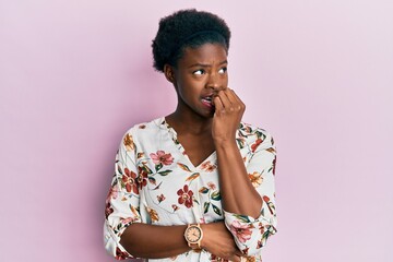 Young african american girl wearing casual clothes looking stressed and nervous with hands on mouth biting nails. anxiety problem. - obrazy, fototapety, plakaty