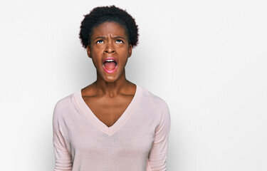Young african american girl wearing casual clothes angry and mad screaming frustrated and furious, shouting with anger. rage and aggressive concept.