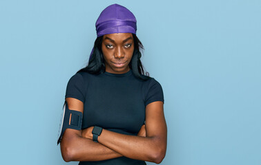 Young african american woman wearing sportswear skeptic and nervous, disapproving expression on face with crossed arms. negative person.