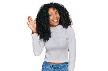 Young african american girl wearing casual clothes waiving saying hello happy and smiling, friendly welcome gesture