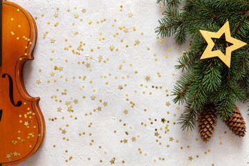 Old violin and fir-tree branches with Christmas decor. Christmas, New Year's concept. Top view, close-up on white background with golden glitter © Eleonora
