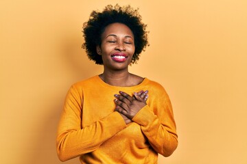 Fototapeta na wymiar Young african american woman wearing casual clothes smiling with hands on chest with closed eyes and grateful gesture on face. health concept.