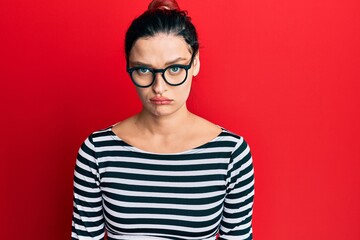 Young caucasian woman wearing casual clothes and glasses skeptic and nervous, frowning upset because of problem. negative person.