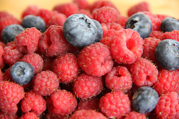 blueberries and raspberries on a wooden background