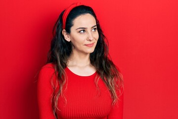 Young hispanic woman wearing casual clothes smiling looking to the side and staring away thinking.