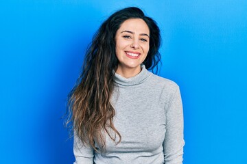 Fototapeta premium Young hispanic woman wearing casual clothes looking positive and happy standing and smiling with a confident smile showing teeth