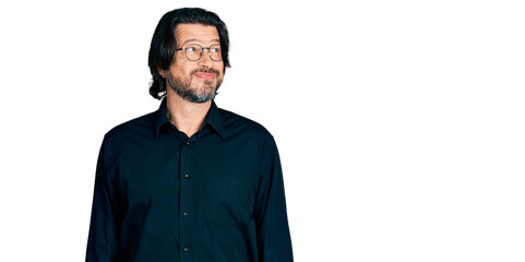 Middle age caucasian man wearing casual clothes and glasses smiling looking to the side and staring away thinking.