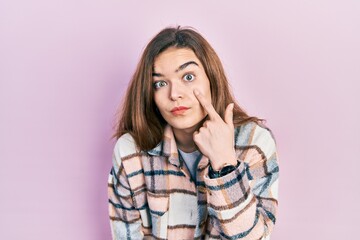 Fototapeta premium Young caucasian girl wearing casual clothes pointing to the eye watching you gesture, suspicious expression