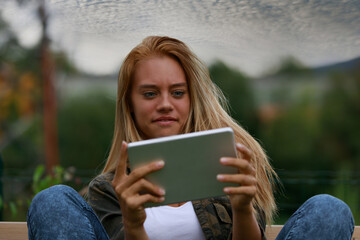 Shocked young woman looking at her tablet in scepticism