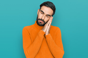 Young hispanic man wearing casual clothes sleeping tired dreaming and posing with hands together while smiling with closed eyes.