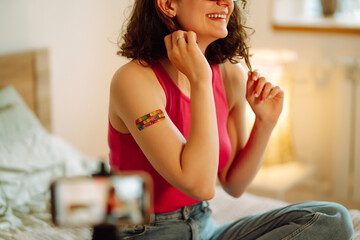 People vaccination concept for immunity health. Woman blogger videotapes her vlog at home and speaking about Vaccine for covid-19. Social media and quarantine. Healthcare, coronavirus, prevention.