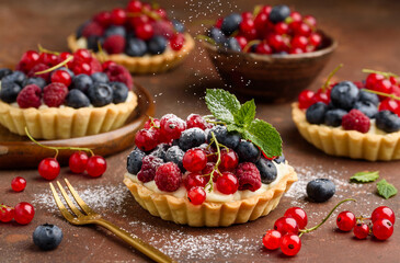 Tartlets with curd cream and fresh berries of raspberries, blueberries, red currants. Summer fruit baking. Close-up. Selective focus 