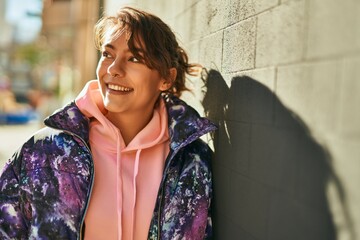 Young hispanic sporty woman smiling happy standing at the city.