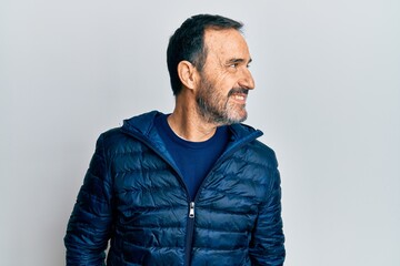 Middle age hispanic man wearing casual clothes looking away to side with smile on face, natural expression. laughing confident.