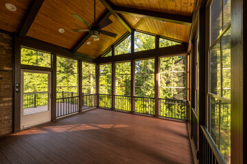 Modern new screened porch with plastic windows and composite floor with summer woods in the...