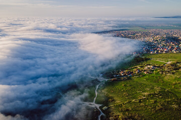 Aerial view with creeping cloud and mountains. Foggy weather