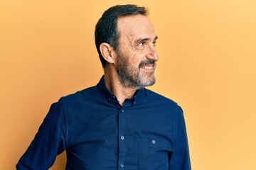 Obraz premium Middle age hispanic man wearing casual clothes looking to side, relax profile pose with natural face and confident smile.