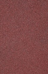 Red rubber floor, texture, background. Relief surface. Faded, old, granular rubber coating and surface with blurry chaotic pattern. Embossed patterns. Abstract elements exterior and interior