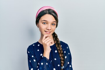 Young brunette girl wearing elegant look looking confident at the camera with smile with crossed arms and hand raised on chin. thinking positive.