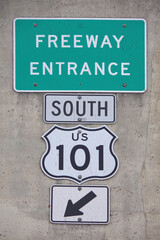 Green FREEWAY ENTRANCE SOUTH 101 sign on a concrete wall