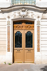 Fototapeta na wymiar Paris, an ancient wooden door, beautiful decorated facade in the 10th arrondissement 