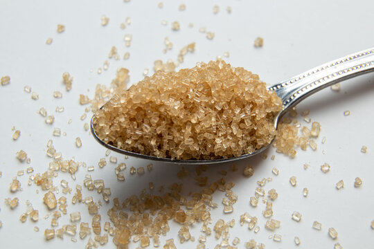 Brown sugar in tablespoons on the light background with copy space, Closeup