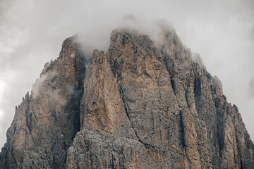 Close up detail photo of rock walls and towers of Dolomites, wrapped in mist and clouds. Steep rock walls in Sella group, Dolomites.