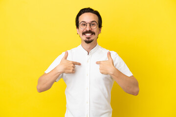 Young caucasian man isolated on yellow background with surprise facial expression