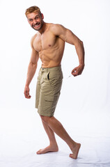 Obraz premium a muscular man in shorts holds a syringe and injects himself in the buttock, grimacing. anabolics, doping, medicine. White background