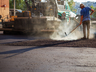 Process of leveling the asphalt manually using a special rake.