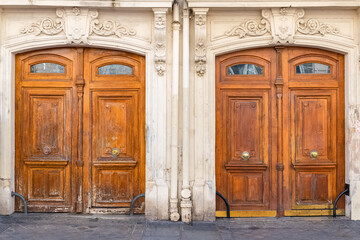 Paris, two ancient wooden doors, typical buildings in the 10e arrondissement, rue de Marseille - obrazy, fototapety, plakaty