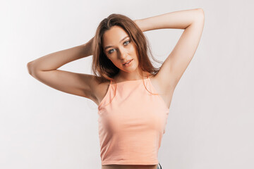Fototapeta premium Beautiful young girl smiling and posing looking at the camera on a white isolated background. Positive brunette woman. Kind look. Beauty face
