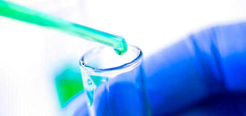 Chemical test tubes and pipette with green liquid close up in a chemical laboratory