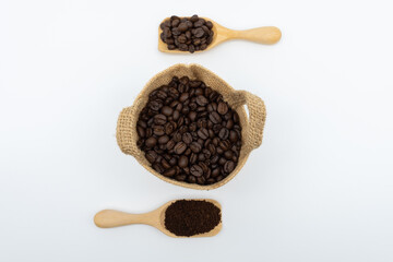 Coffee beans and ground coffee in wooden spoon with hemp sack bag isolated on white background.
