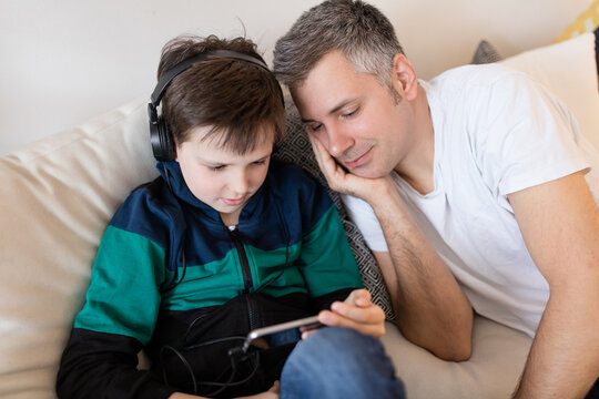Son and father playing game on smartphone