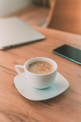 Coffee cup with laptop computer and mobile smart phone on freelancer's desk