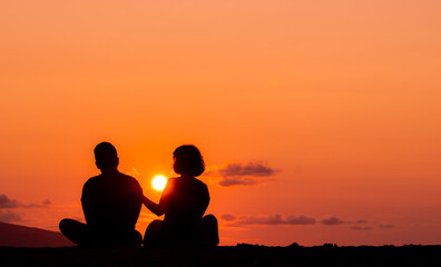 Fototapeta na wymiar Harmony between couple at the beach, silhouette during sunset, lovers.
