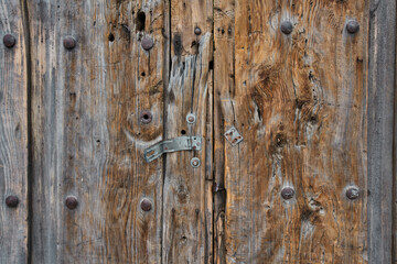 Puerta antigua de madera con herrajes oxidados